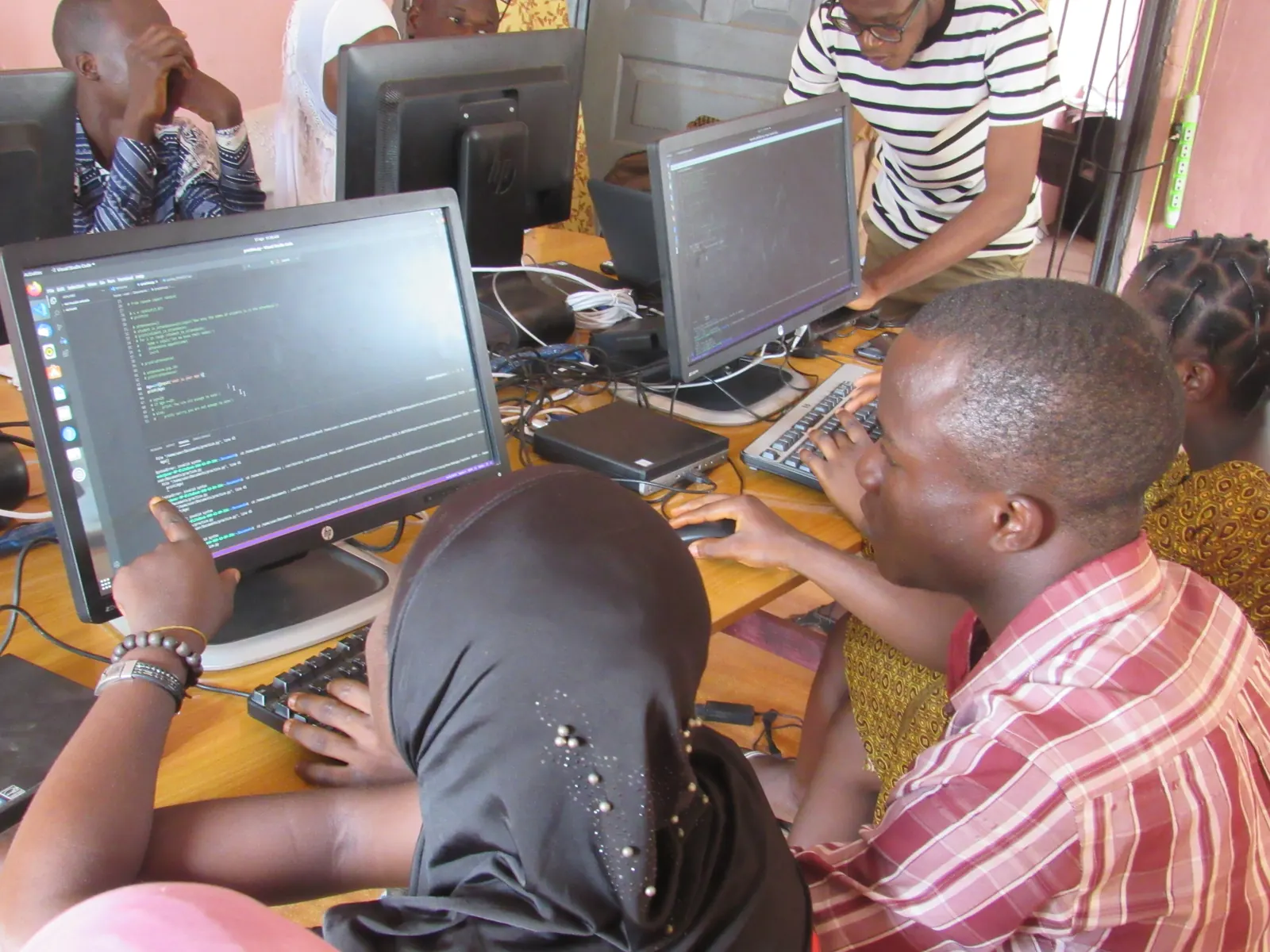 Students at computer workstations debugging a script together at MYTECHDEV's Ilesha computer lab.