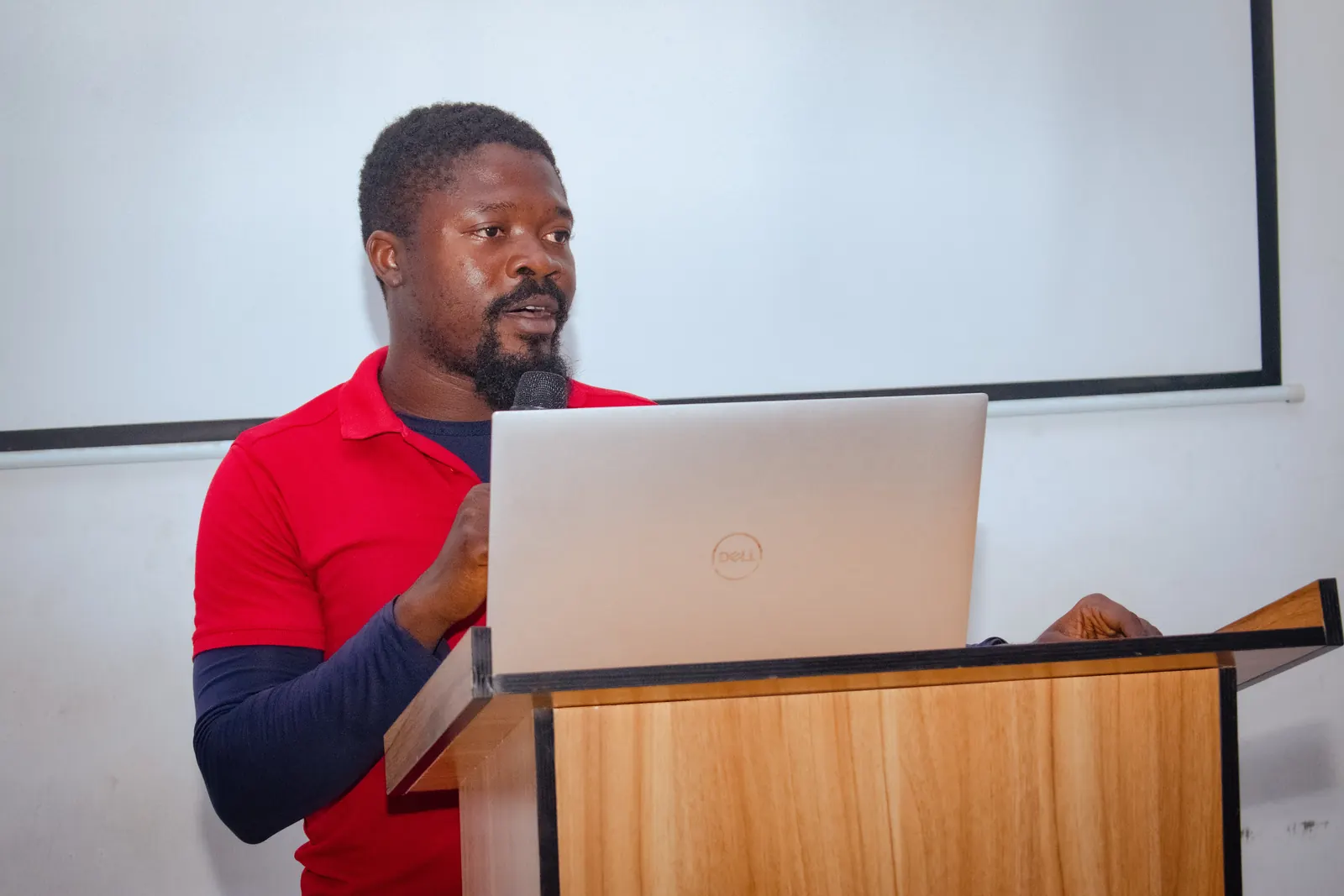 An instructor leading a MongoDB training session in a lecture hall.